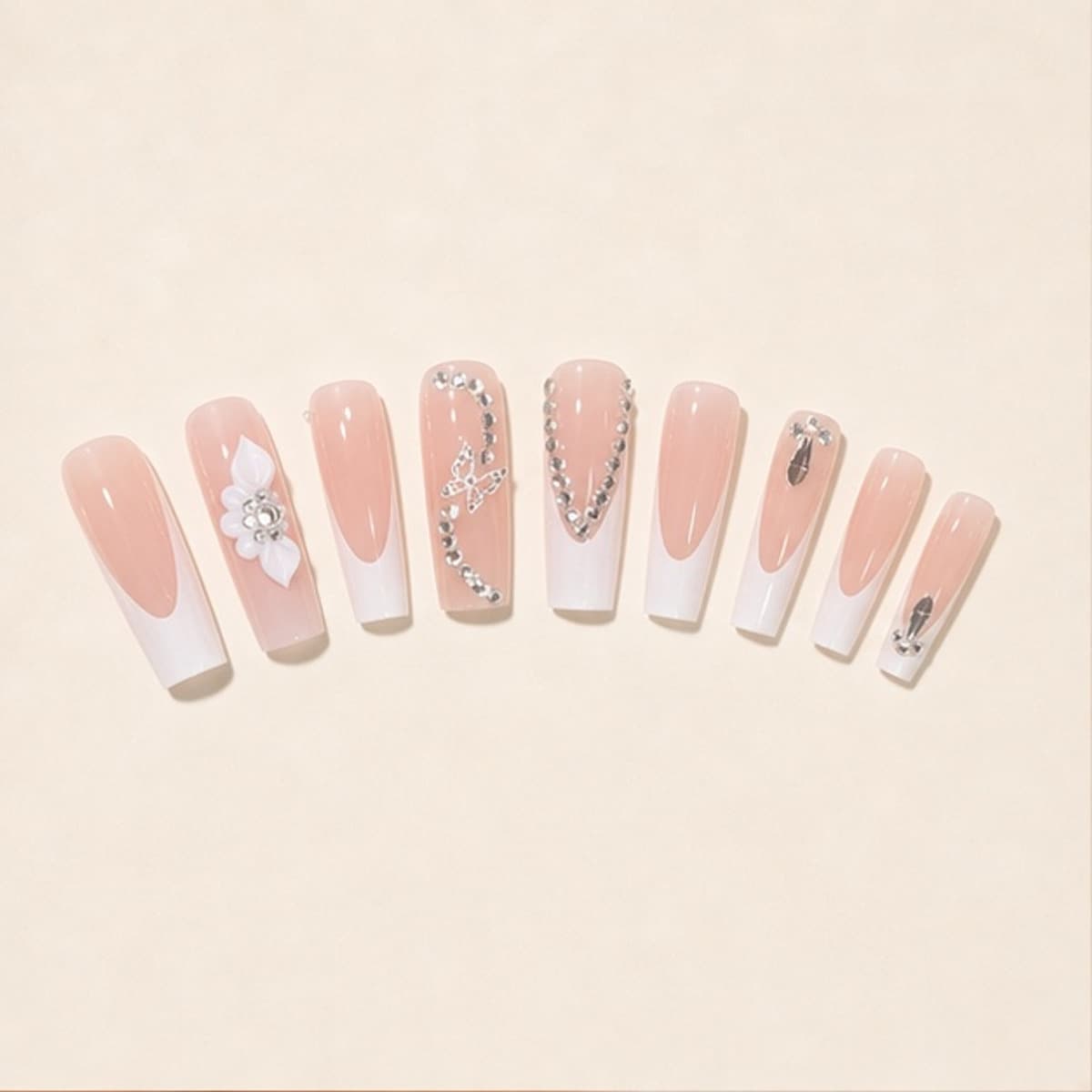 Étoile crystal flower chain French press-on nail set arranged in a fan on an ivory background