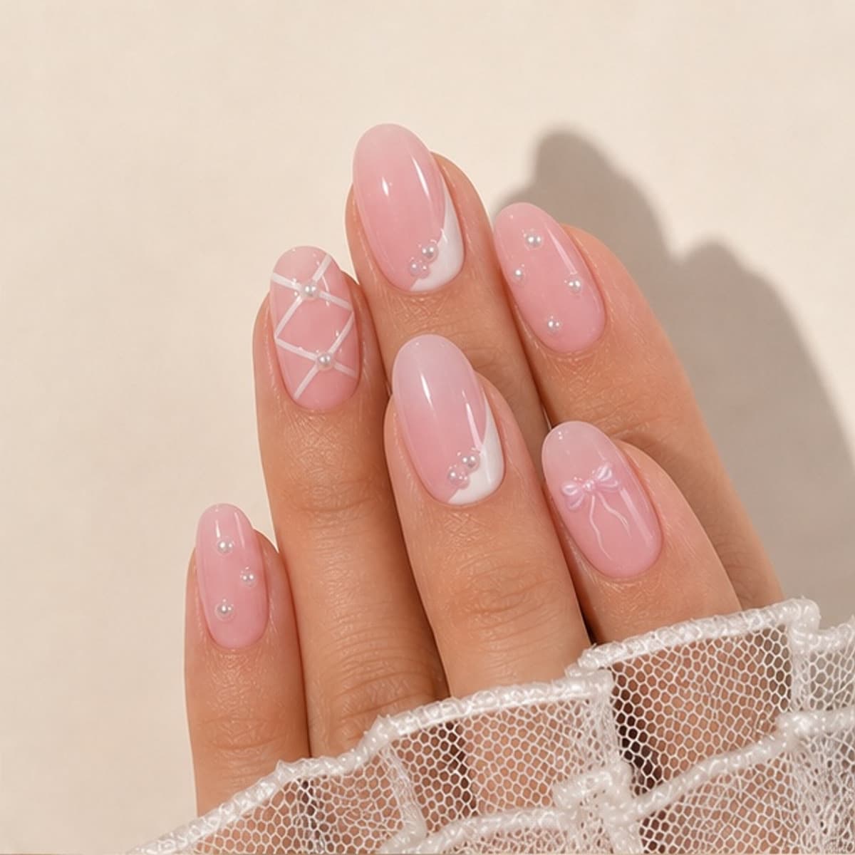 Opaline short hand-painted pink French press-on nails worn on a relaxed hand against a cream background