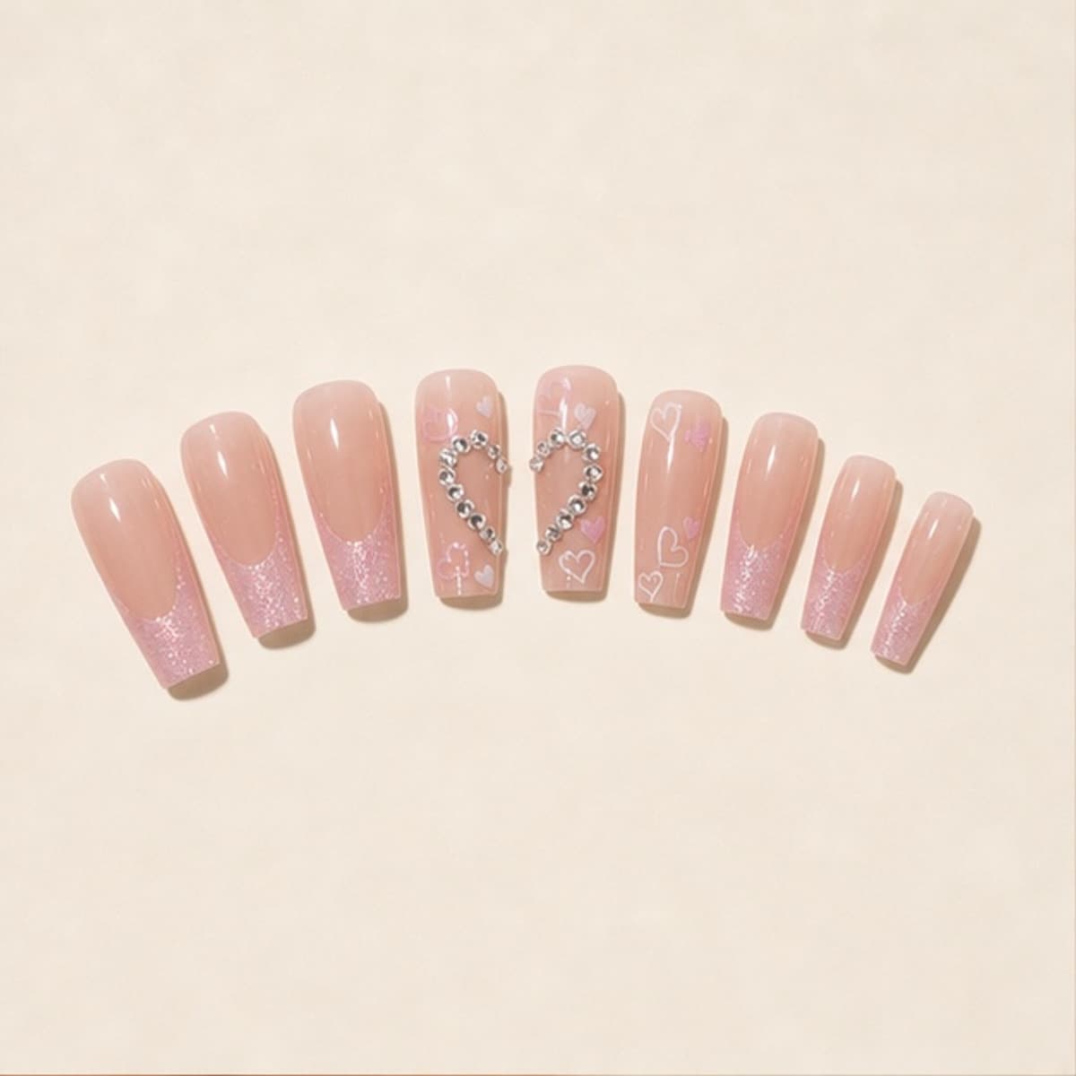 Perle crystal heart blush press-on nail set arranged in a fan on an ivory background