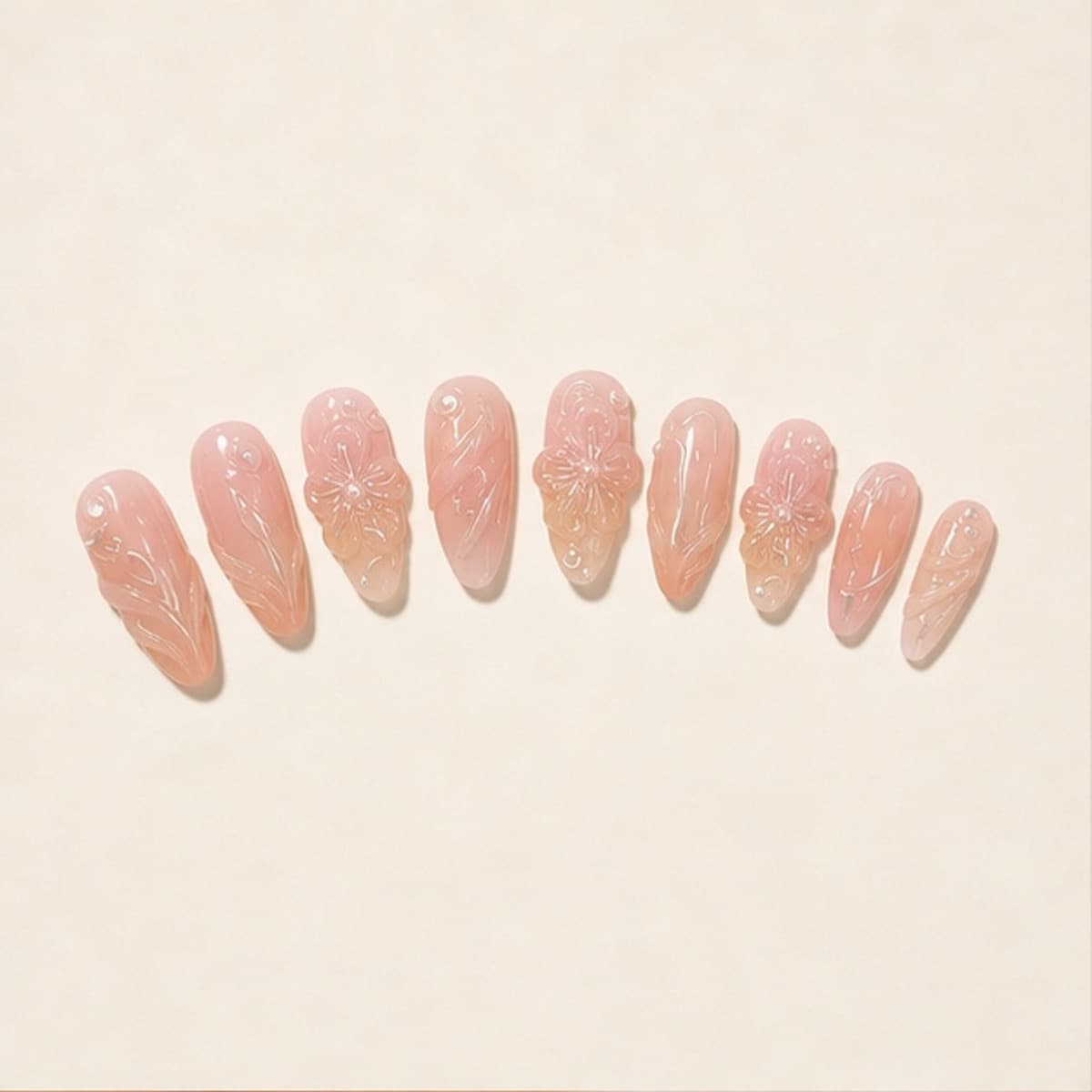 Roseraie sculpted nude floral press-on nail set arranged in a fan on an ivory background