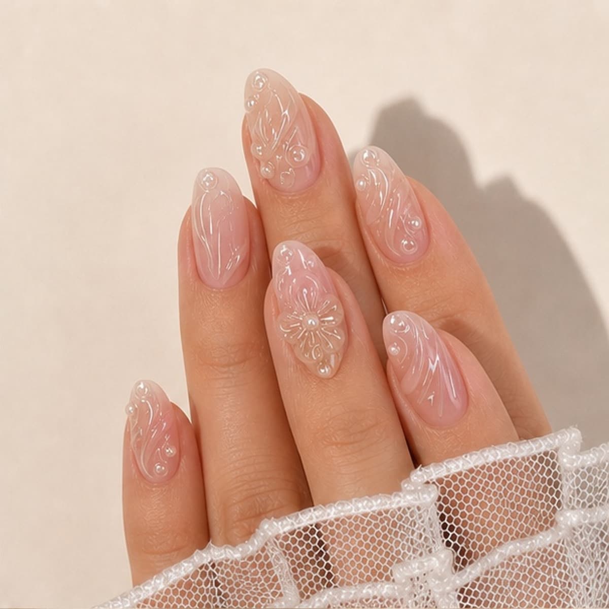 Roseraie sculpted nude floral press-on nails worn on a relaxed hand against a cream background