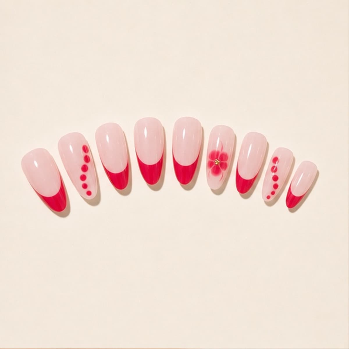 Rubis ruby floral French press-on nail set arranged in a fan on an ivory background