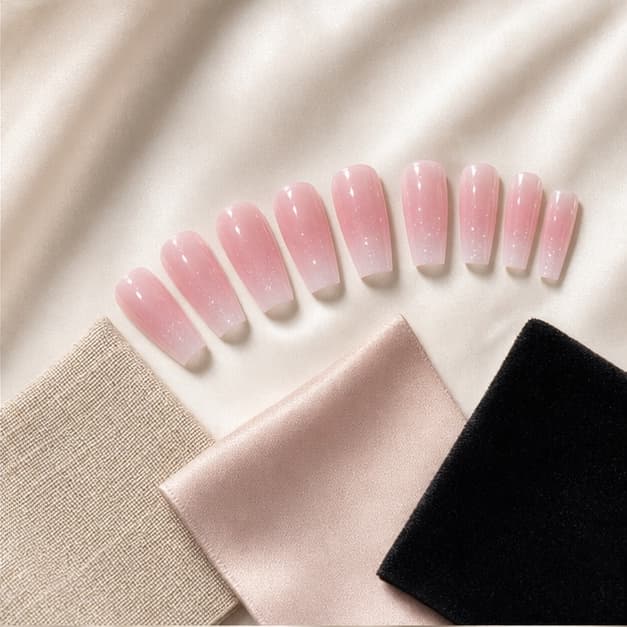 Nacre press-on nails arranged beside warm material swatches